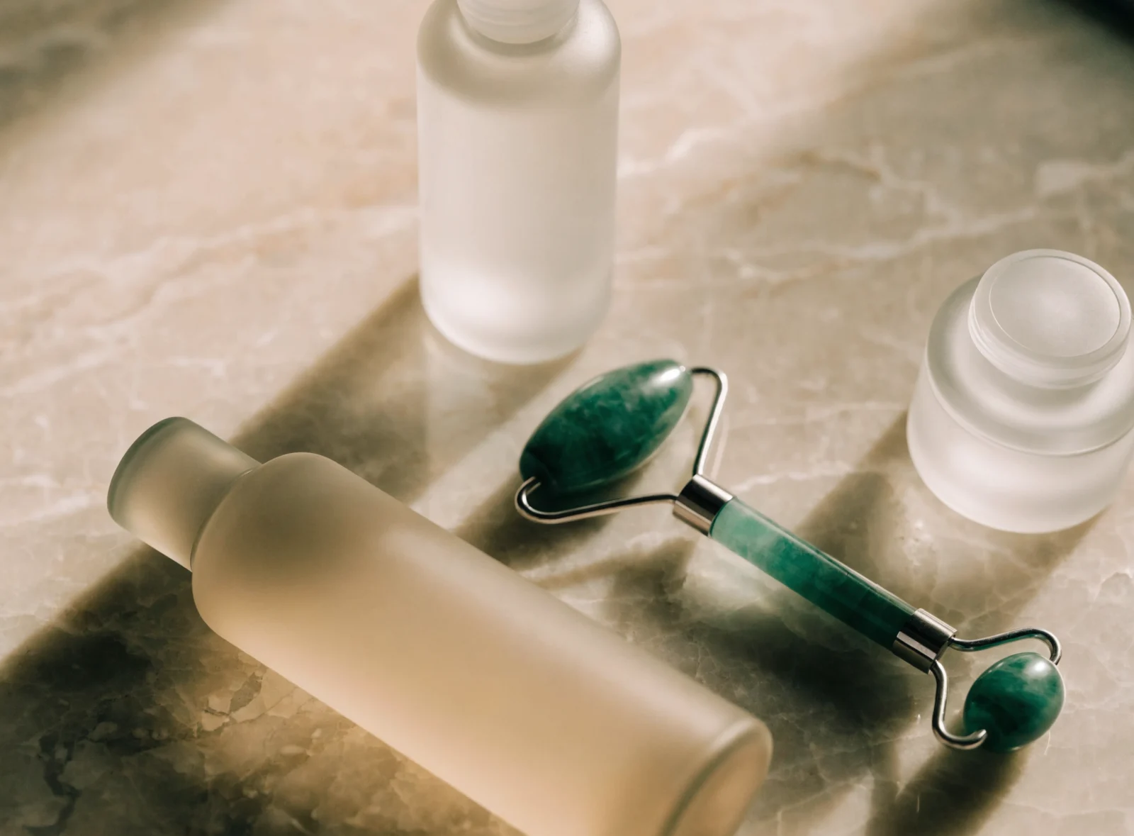 Skincare bottles and a jade roller