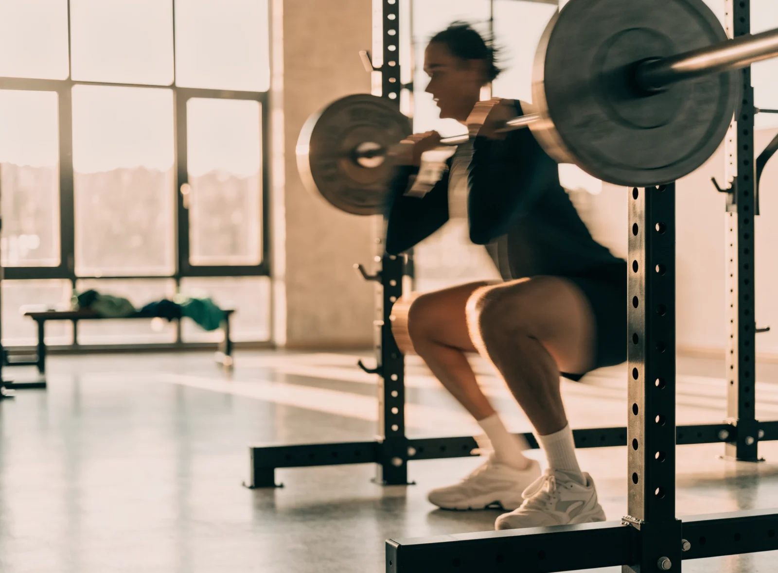 Person performing a squat in a bright gym